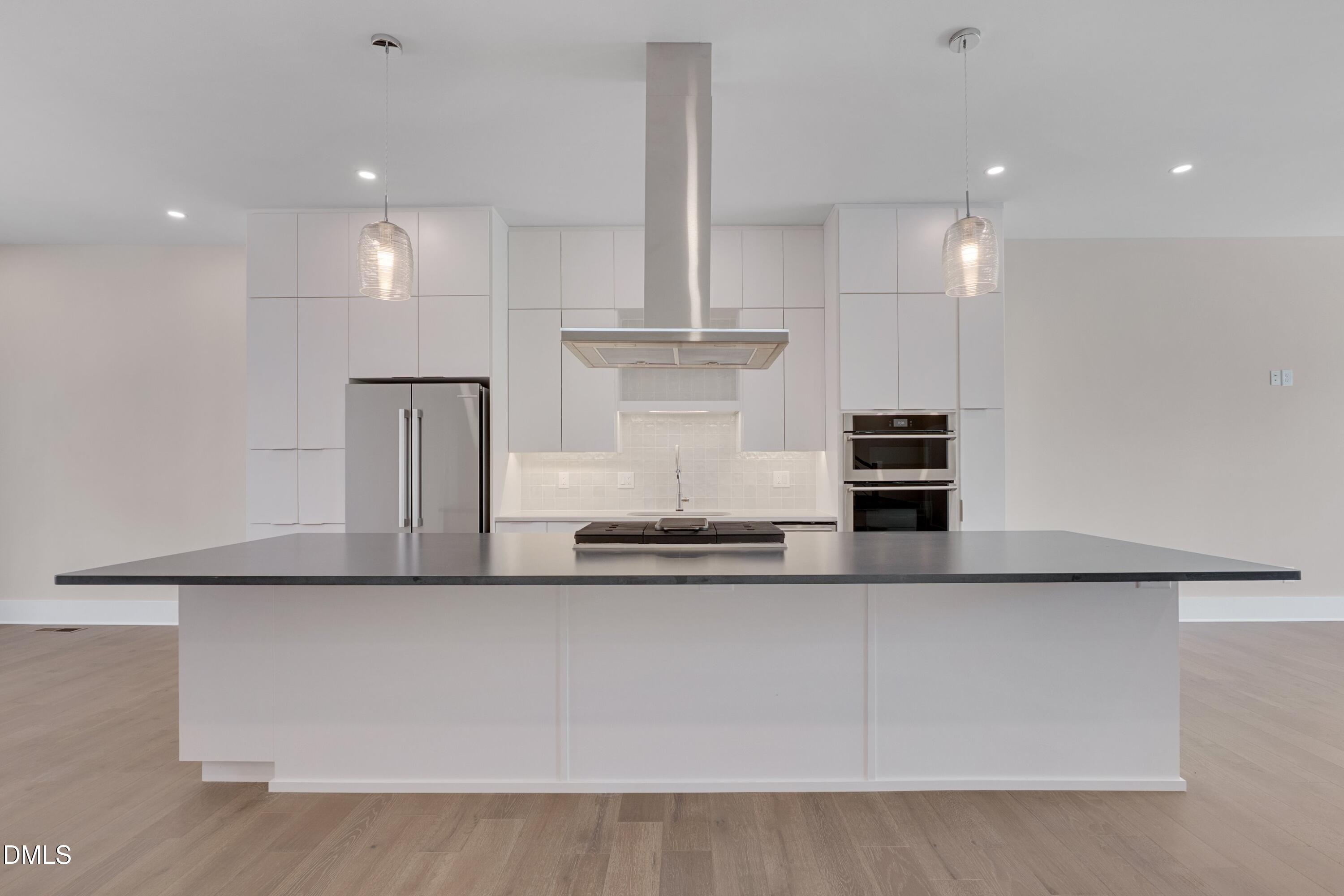 1014 Manor Way Durham, NC 27701 - Photo 12 of 38 a kitchen with kitchen island stainless steel appliances a sink and a refrigerator