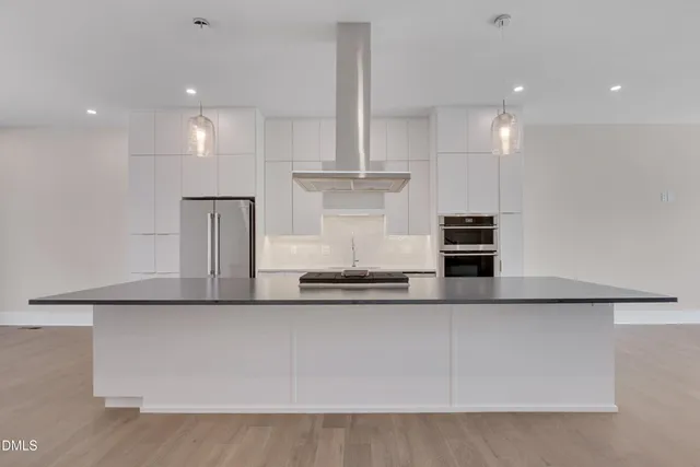 a view of an empty room with wooden floor and stairs