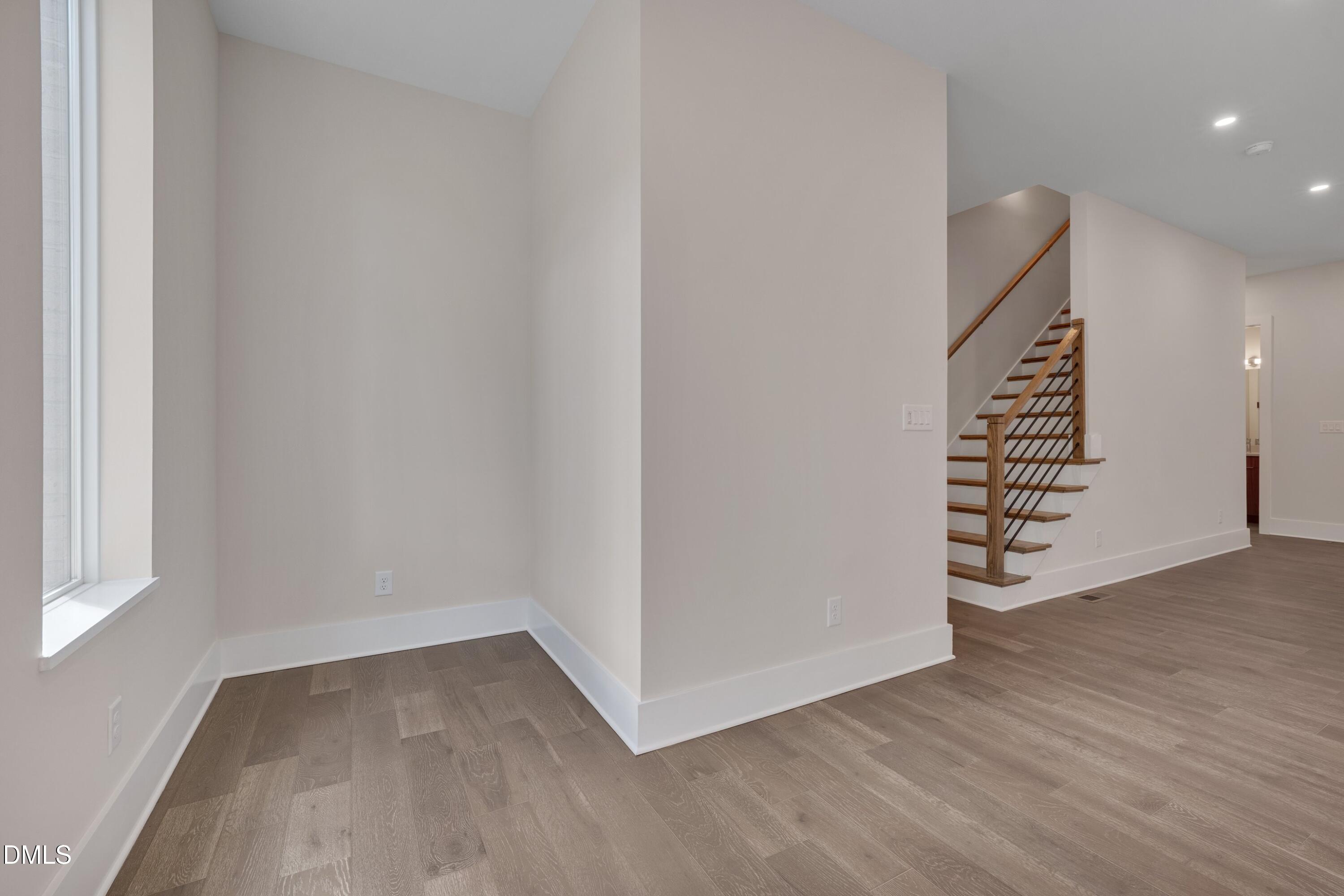 1014 Manor Way Durham, NC 27701 - Photo 21 of 38 a view of an empty room with wooden floor and stairs