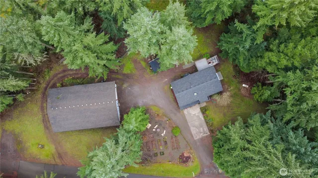 an aerial view of a house with a yard lake and trees all around