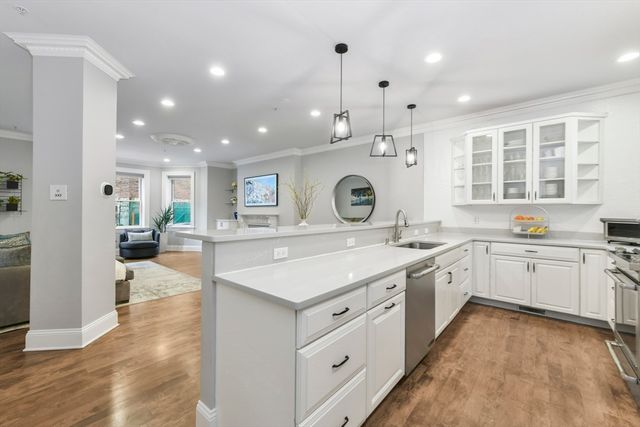 a large kitchen with kitchen island a sink stainless steel appliances and cabinets