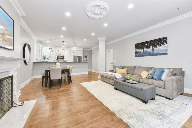 a living room with furniture kitchen view and a chandelier