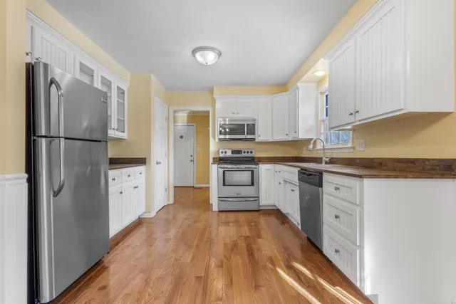 a kitchen with white cabinets and stainless steel appliances