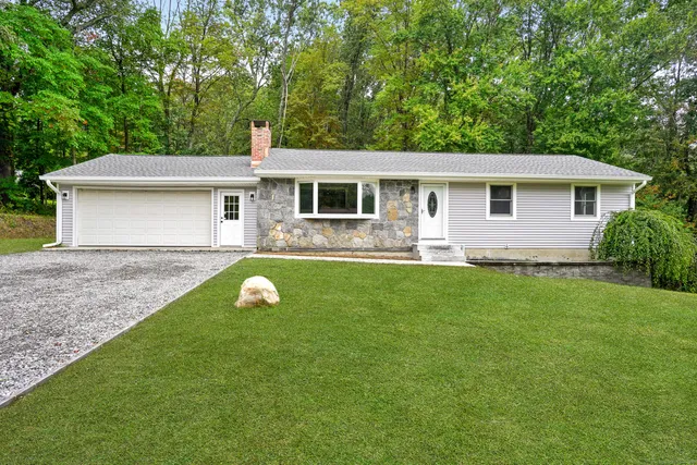 a front view of house with yard and green space