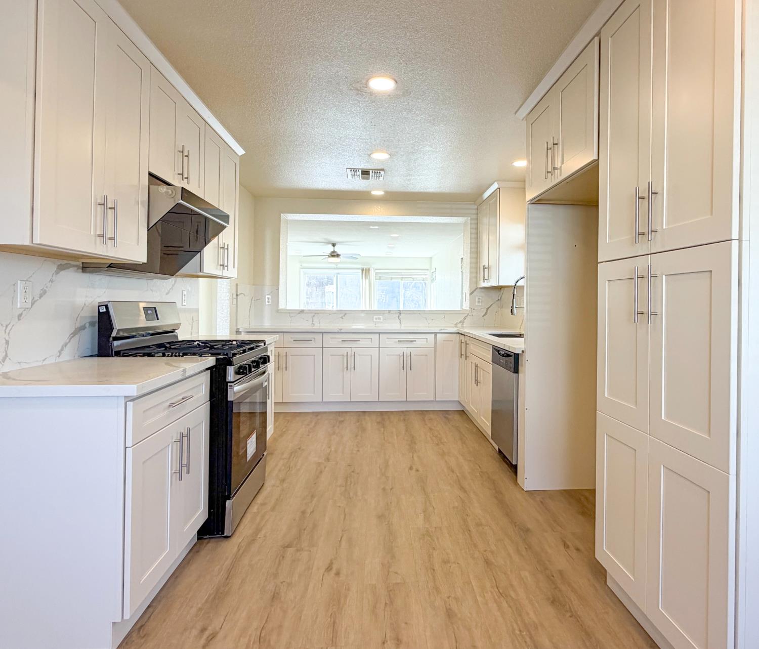 7948 Cavalier Way Sacramento, CA 95832 - Photo 4 of 17 a large kitchen with cabinets wooden floor and stainless steel appliances