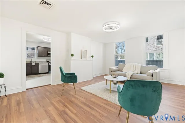a living room with furniture and a wooden floor