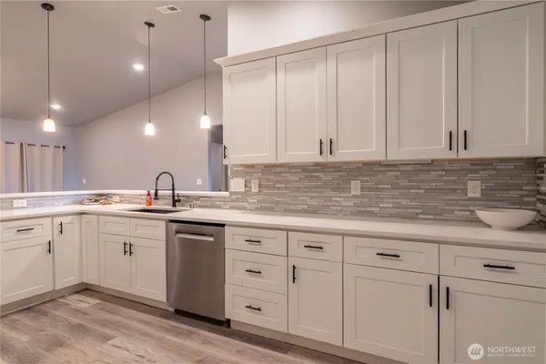 a kitchen with white cabinets and sink