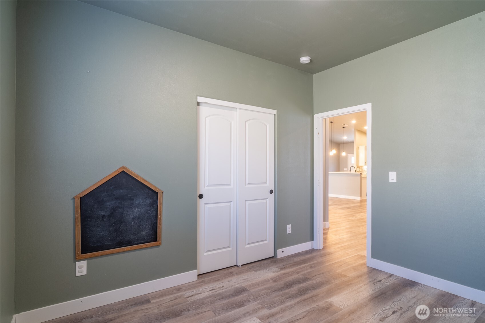 352 East Davis Street Connell, WA 99326 - Photo 33 of 40 an empty room with wooden floor and painting on the wall