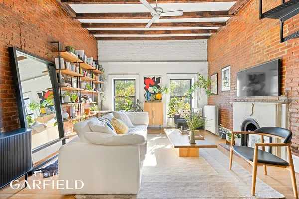 a living room with fireplace furniture and a painting on the wall
