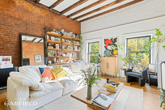 a living room with patio furniture and a potted plant
