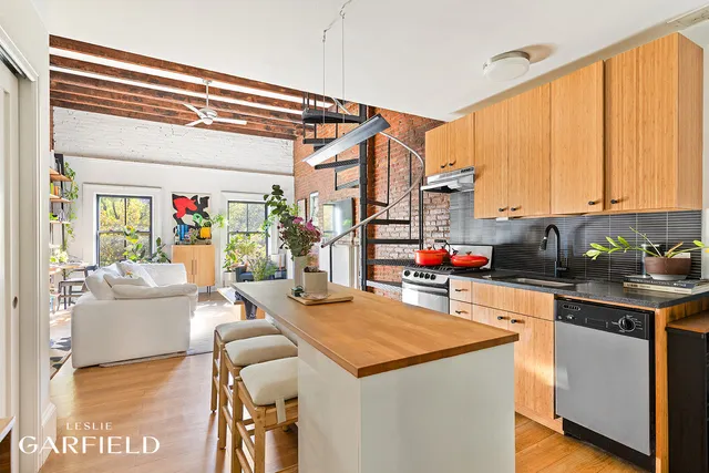 a living room with stainless steel appliances kitchen island granite countertop a sink and cabinets