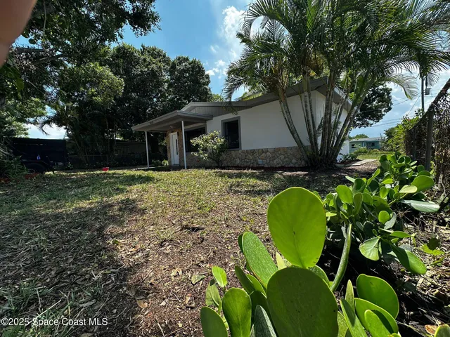 a backyard of a house with table and chairs