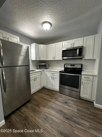 a kitchen with a refrigerator a stove top oven a sink and dishwasher