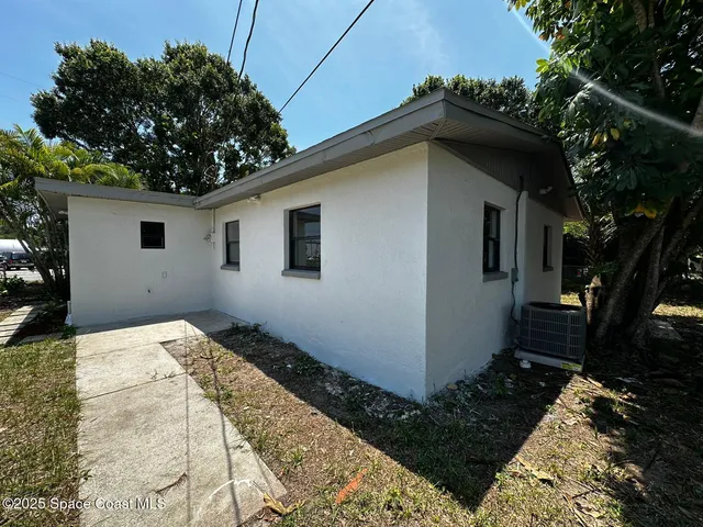 a white house with a large tree