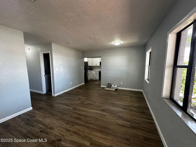 a view of a livingroom with wooden floor and staircase
