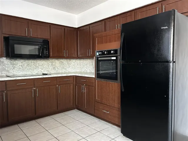 a kitchen with granite countertop a refrigerator and a stove