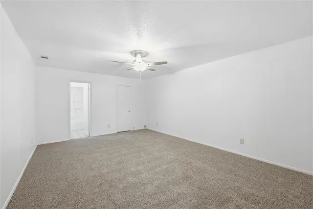 an empty room with a chandelier fan