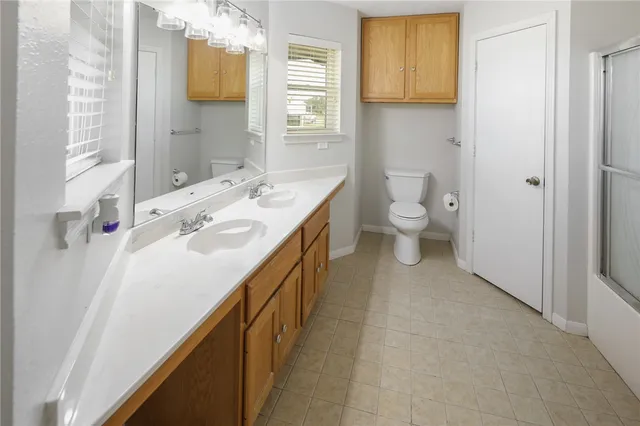 a bathroom with a sink a toilet and a mirror