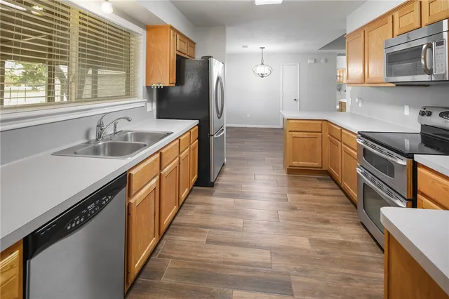 a kitchen with stainless steel appliances granite countertop a sink a stove and a refrigerator