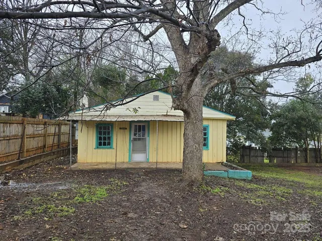 a view of a house with yard and a tree