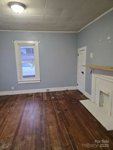 a view of a room with wooden floors and fireplace