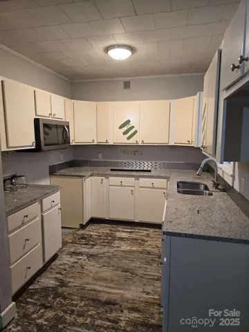 a kitchen with stainless steel appliances granite countertop a sink a stove a microwave a sink and cabinets