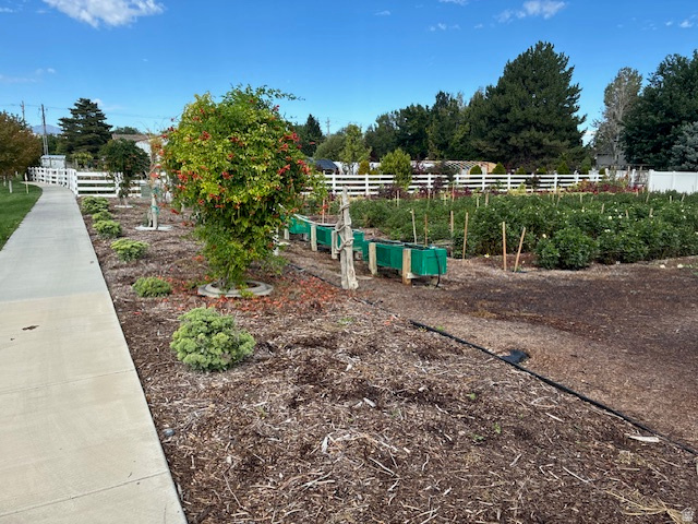 367 Pheasant View Drive, Unit 2 Draper, UT 84020 - Photo 1 of 13 Manicured landscaping with established trees and shrubs, paved pathway, and white picket fencing