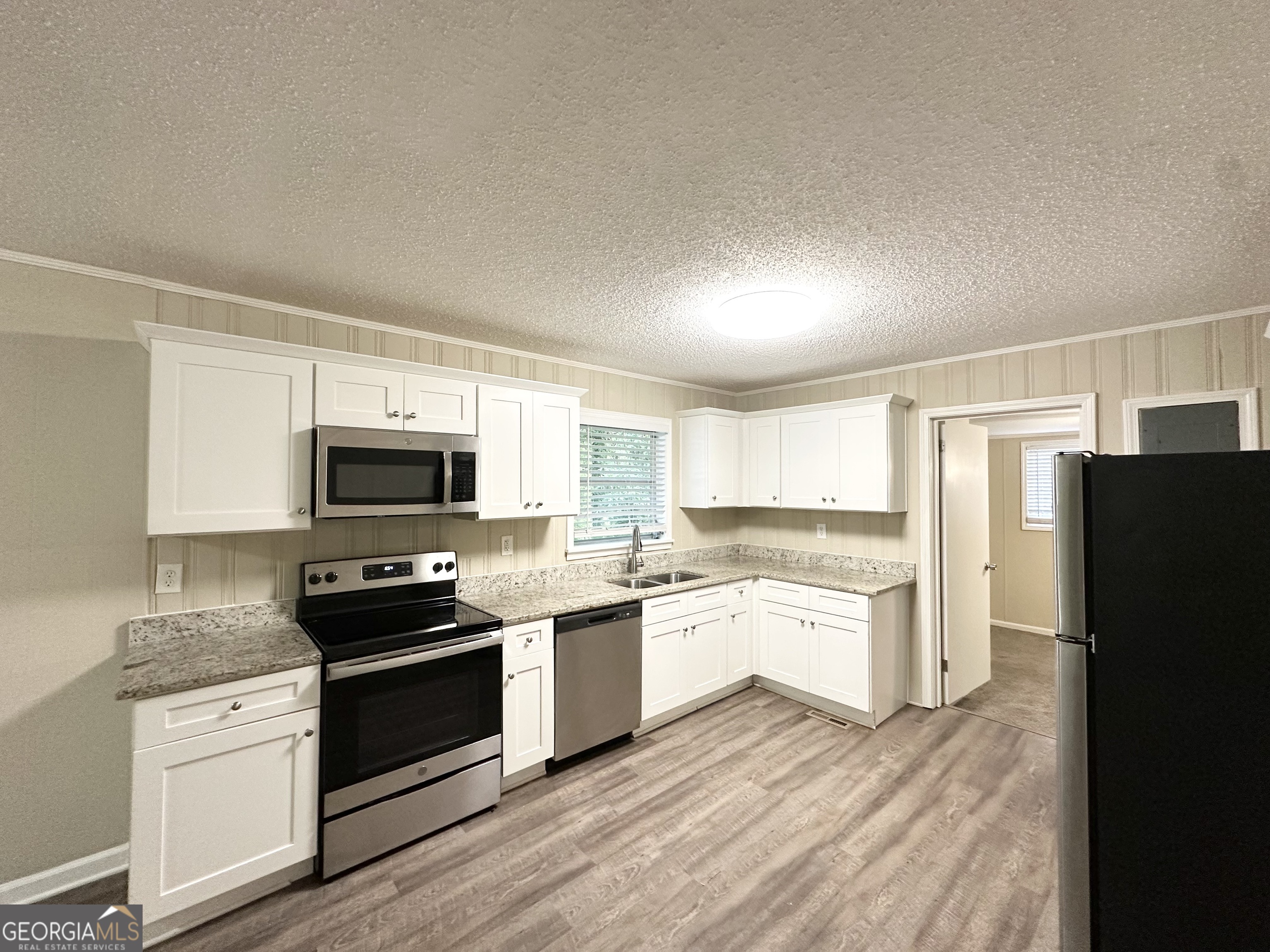 4385 Midway Road Douglasville, GA 30134 - Photo 5 of 12 a kitchen with a sink a stove a refrigerator and white cabinets