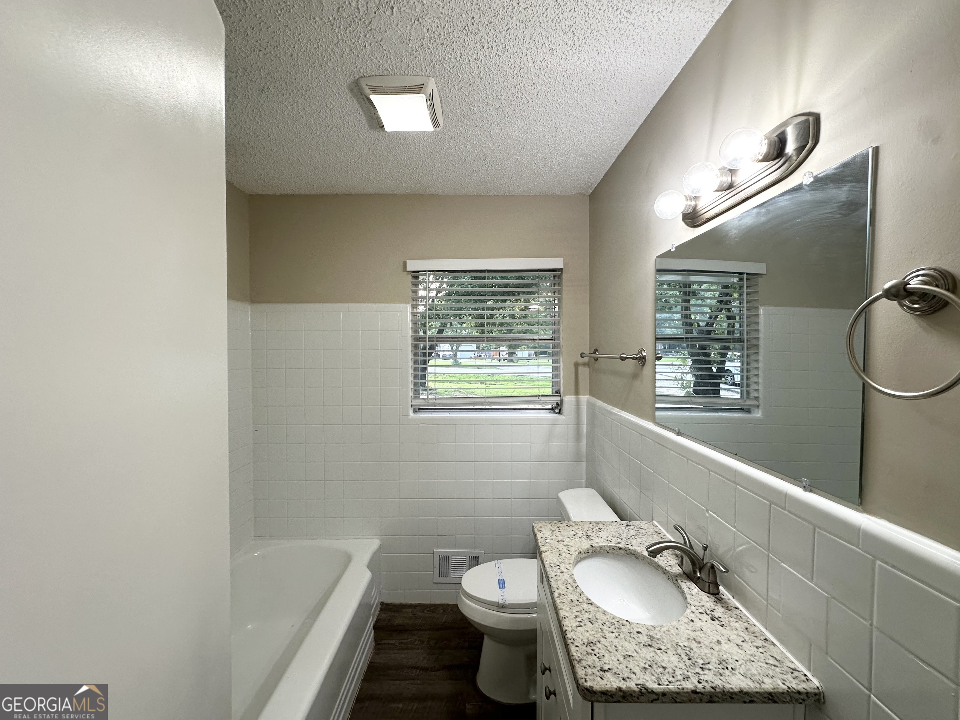 4385 Midway Road Douglasville, GA 30134 - Photo 9 of 12 a bathroom with a granite countertop bathtub sink vanity mirror and toilet