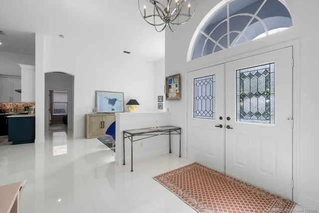 a living room with furniture and a chandelier