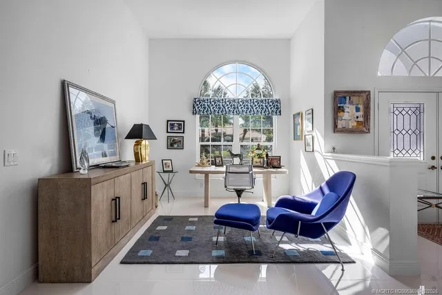 a spacious bedroom with a bed a chandelier and dresser