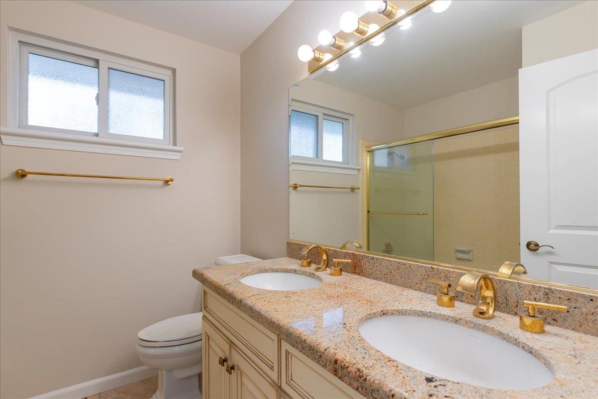 8501 King Road Loomis, CA 95650 - Photo 45 of 89 a bathroom with a granite countertop sink a toilet and a mirror