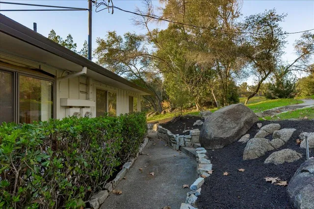 an aerial view of residential house with outdoor space and trees all around