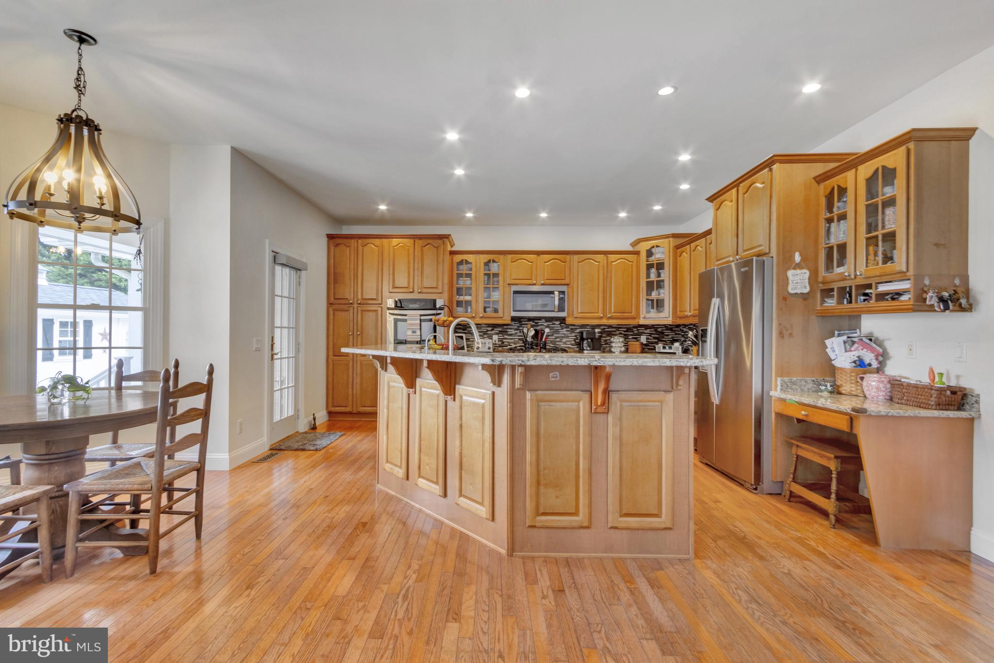 16132 Hudson Road Milton, DE 19968 - Photo 29 of 108 a kitchen with stainless steel appliances granite countertop a refrigerator a stove top oven and a dining table with wooden floor