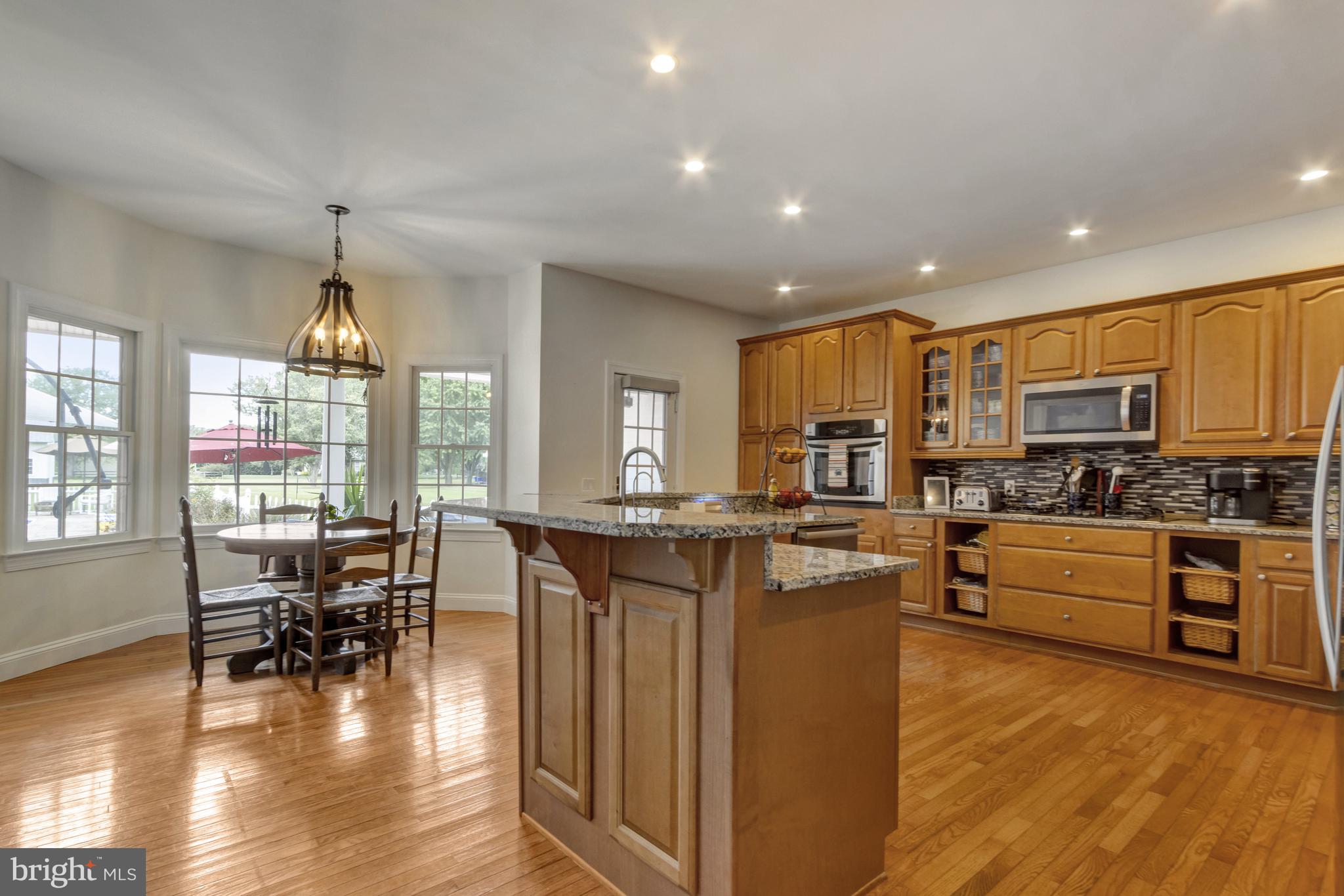 16132 Hudson Road Milton, DE 19968 - Photo 30 of 108 a kitchen with stainless steel appliances granite countertop wooden cabinets a stove top oven a dining table and chairs