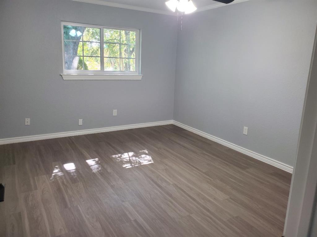 206 Springbranch Drive Garland, TX 75043 - Photo 11 of 12 wooden floor in an empty room with a window