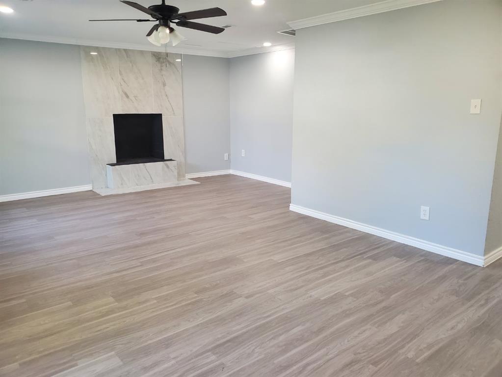 206 Springbranch Drive Garland, TX 75043 - Photo 4 of 12 a view of a room with wooden floor and a ceiling fan