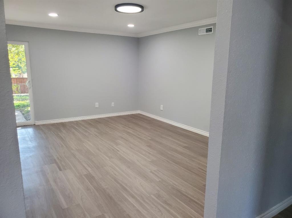 206 Springbranch Drive Garland, TX 75043 - Photo 5 of 12 an empty room with wooden floor and windows