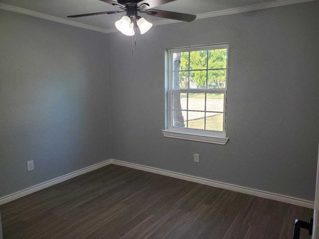 206 Springbranch Drive Garland, TX 75043 - Photo 10 of 12 a view of an empty room with wooden floor and a window