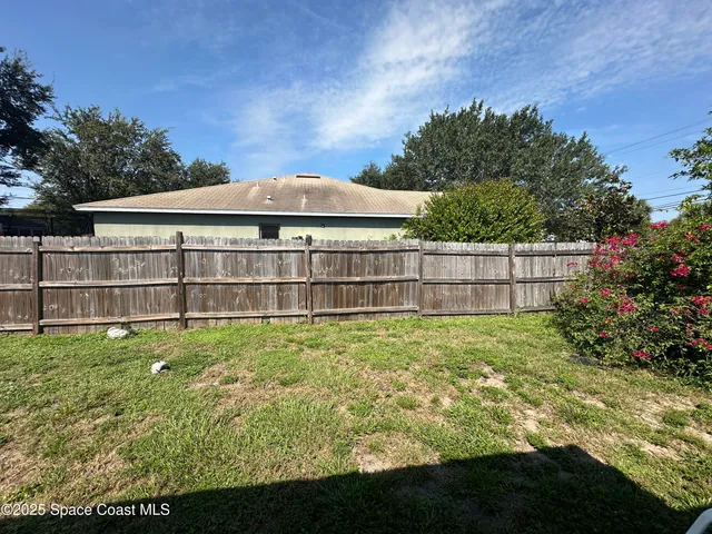 a view of a garden with a house in the background