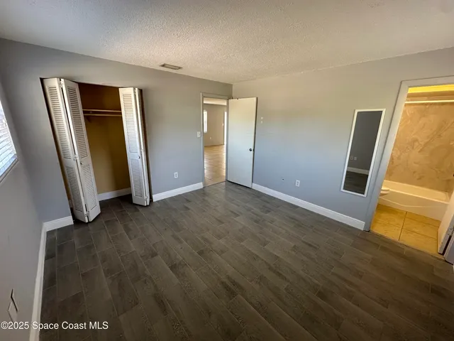 an empty room with wooden floor and closet