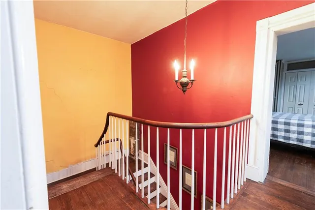 a view of a hallway with wooden floor and staircase