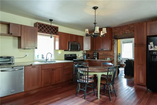 a view of a dining room and livingroom with furniture wooden floor a chandelier