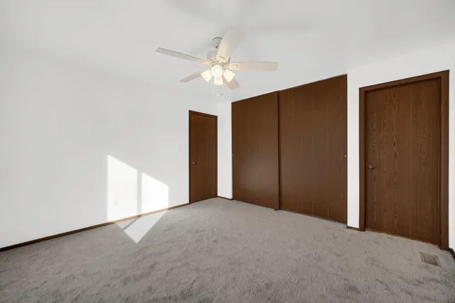 a view of an empty room with a ceiling fan