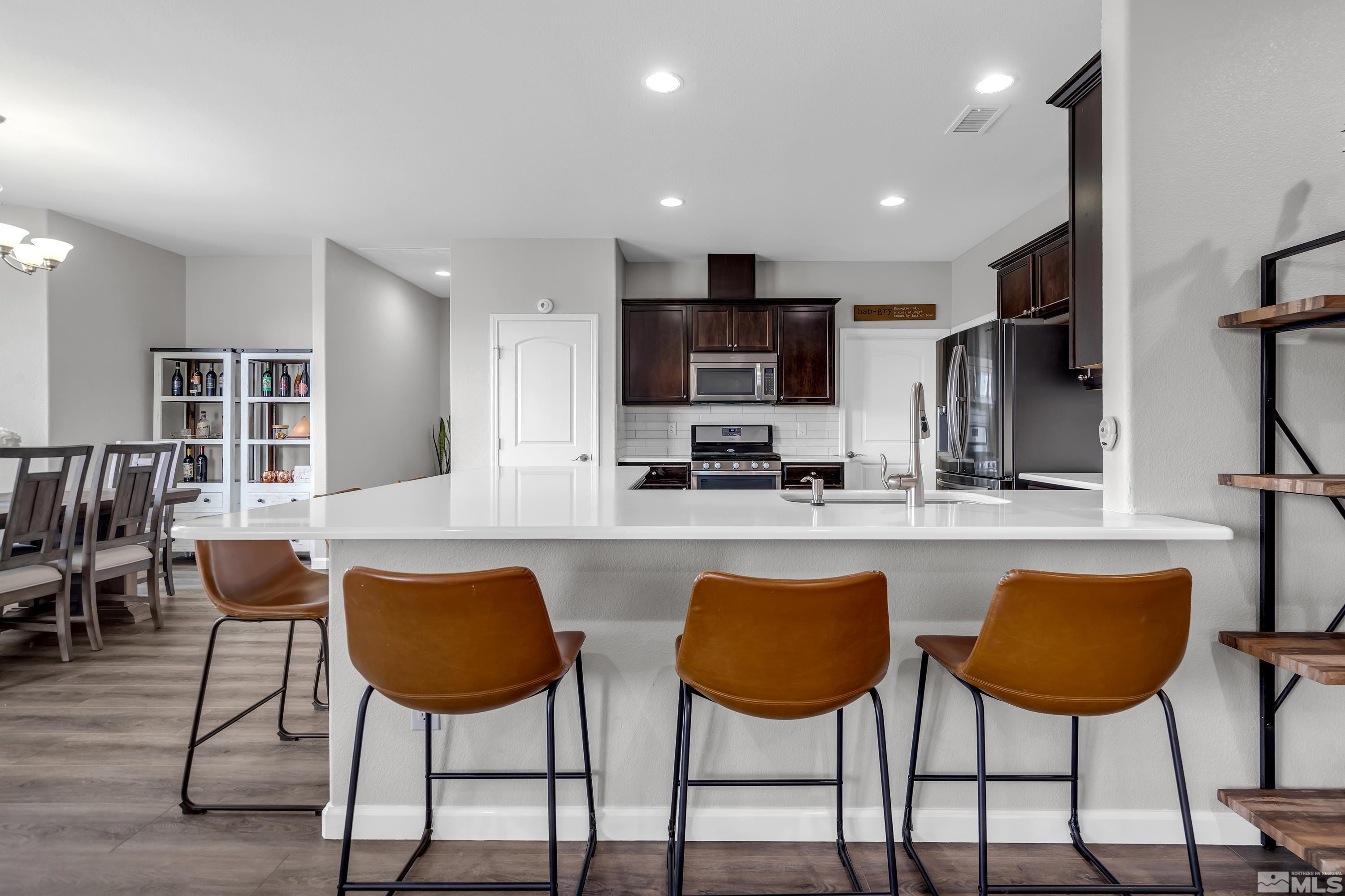 2255 Makenna Drive Reno, NV 89521 - Photo 6 of 34 a kitchen with stainless steel appliances kitchen island a table and chairs in it