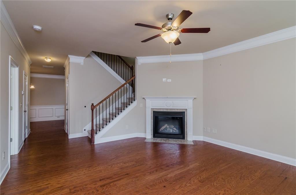 449 Privet Circle Suwanee, GA 30024 - Photo 2 of 9 a view of an empty room wooden floor fireplace and a window