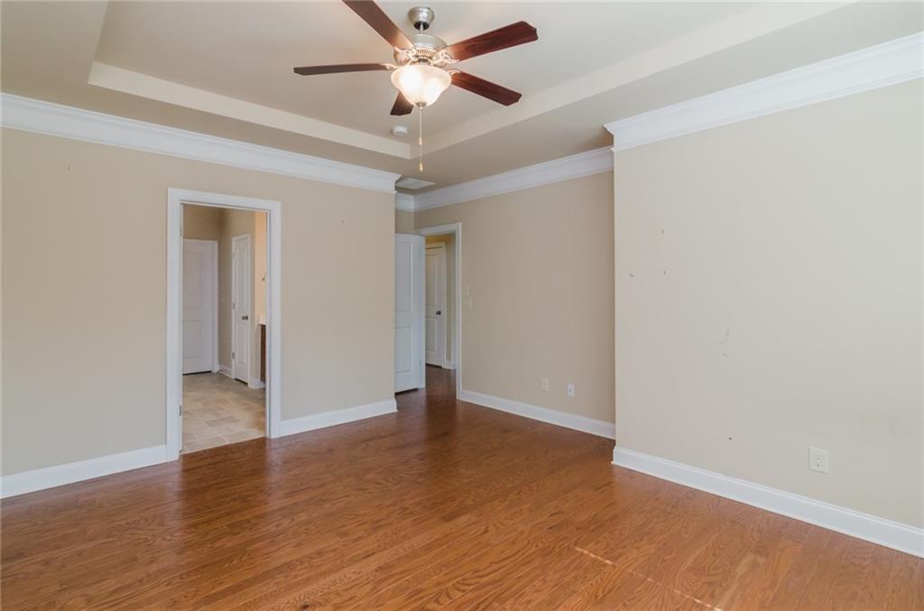 449 Privet Circle Suwanee, GA 30024 - Photo 5 of 9 an empty room with wooden floor and a ceiling fan