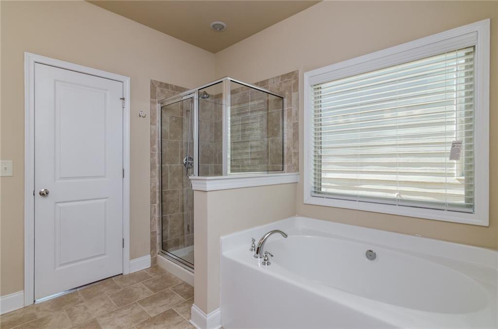 449 Privet Circle Suwanee, GA 30024 - Photo 7 of 9 a bathroom with a bathtub and a shower
