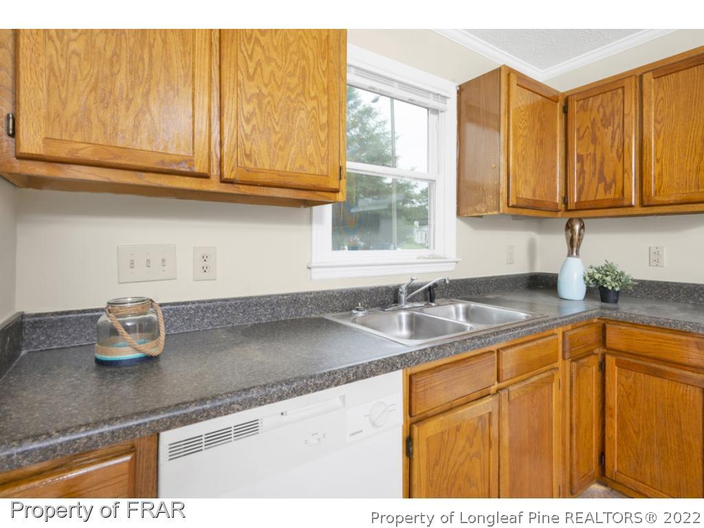6549 Rhemish Drive Fayetteville, NC 28304 - Photo 12 of 27 a kitchen with granite countertop a sink stainless steel appliances cabinets and a counter top space