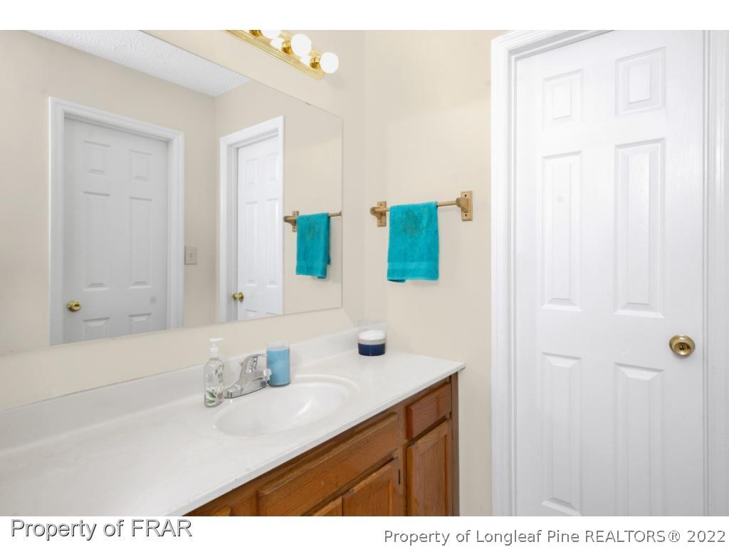 6549 Rhemish Drive Fayetteville, NC 28304 - Photo 18 of 27 a bathroom with a sink and a mirror